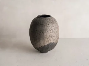 ceramic vase, hand-thrown in France, artisan ceramic art, quiet power of mineral textures, soft smoke hues, rare piece of French ceramic art, crafted in a Paris atelier