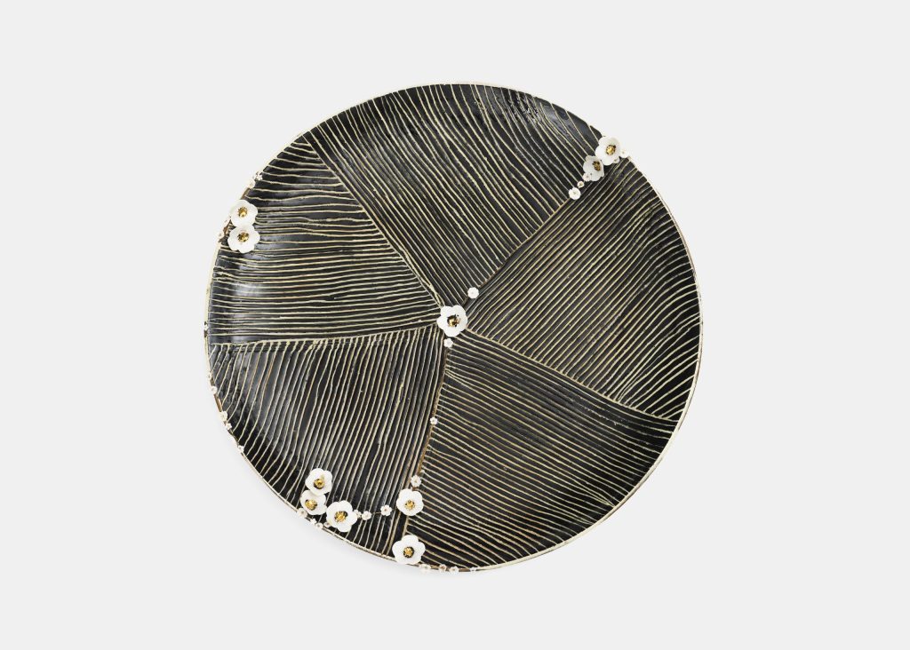 Plat kintsugi tonigawa de Karen Swami orné de fines branches et fleurs en porcelaine.