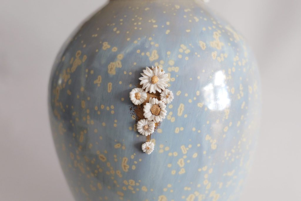 Vase kintsugi de Karen Swami orné de fleurs en porcelaine.