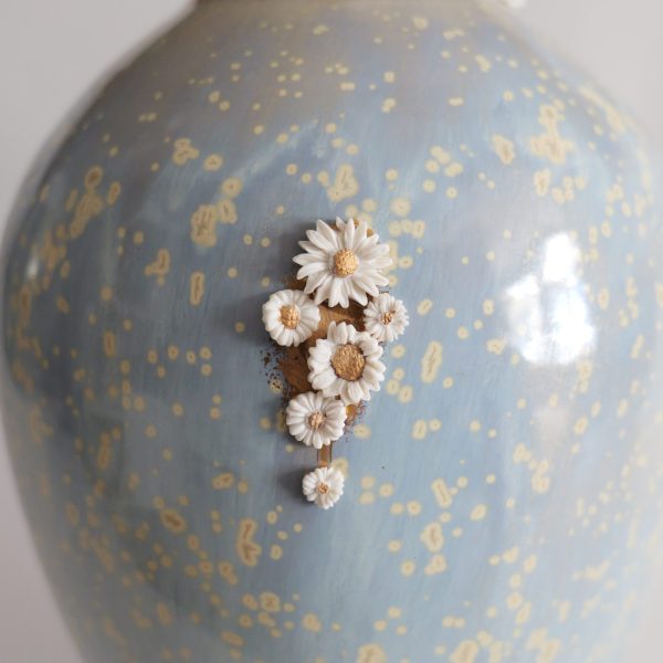 Vase kintsugi de Karen Swami orné de fleurs en porcelaine.