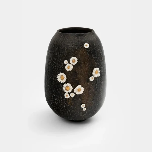 Vase noir texturé de Karen Swami avec décor de fleurs blanches en relief.