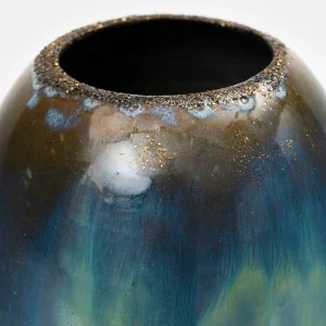 Close-up of a handmade ceramic vase, vibrant blue-green glaze with flowing texture and refined gold lustre details