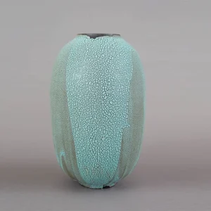 An elongated ceramic vessel, with artisan crackle glaze, in soft aqua and ash tones, modern collectible, brings quiet elegance to any interior