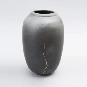 vase-kintsugi-made-in-france-gres-piece-unique-laque-vegetable-or-gris-fonce-avec-nuances-blanc-poli vase en céramique noir mat, décoré de réparation kintsugi, une unique fissure dorée verticale, pièce contemporaine en grès tournée, à la main, objet d’art minimaliste, design épuré, céramique japonaise inspirée, création unique, décoration haut de gamme, design luxe